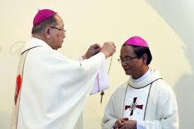 Đức cha Antôn Vũ Huy Chương (trái), Giám mục giáo phận Đà Lạt, trao mũ và Thánh giá cho Đức Giám mục tân cử Giuse Nguyễn Đức Cường (hôm 25/4) tại nhà thờ Bảo Lộc sau khi Tòa Thánh công bố bổ nhiệm Giám mục của ngài. Ảnh: CTV