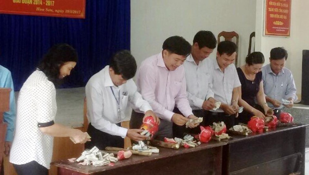 Cán bộ và các hội, đoàn thể xã Hòa Sơn "mổ" heo đất. Ảnh: CTV