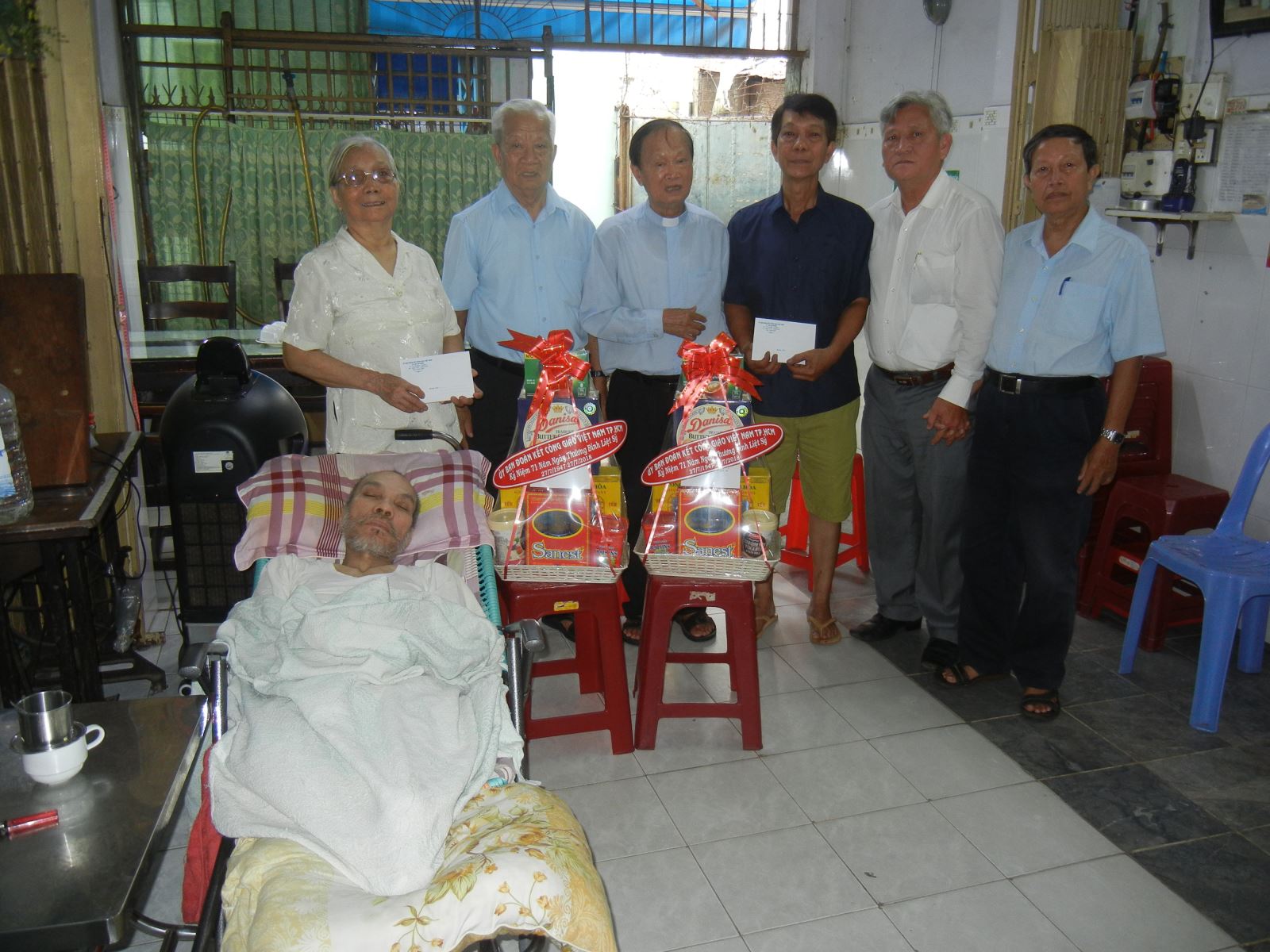 Linh mục Phêrô Phan Khắc Từ cùng đại diện Ủy ban ĐKCG TP.HCM và đại diện giáo xứ Vĩnh Hòa đến thăm, tặng quà gia đình 2 thương binh. Ảnh: VĐHT