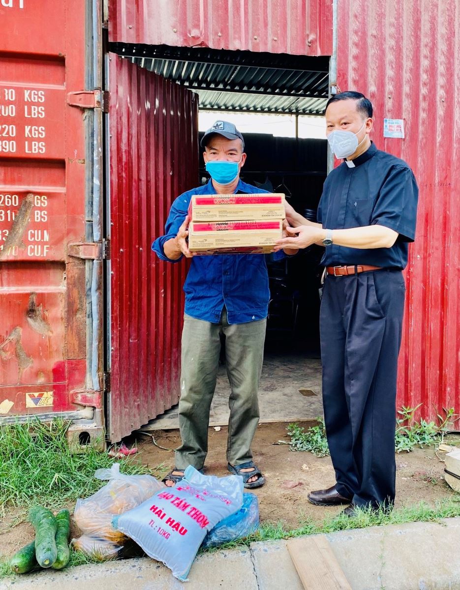 Cha Phanxicô Xavie Nguyễn Huy Liệu trao nhu yếu phẩm cho người lao động bị “kẹt” lại tại xã Nội Hoàng, Yên Dũng, Bắc Giang. Ảnh: An Luých
