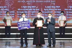 Thủ tướng Chính phủ Phạm Minh Chính trao chứng nhận, hoa cảm ơn Tổng Giám mục Vũ Văn Thiên, Phó Tổng Thư ký Hội đồng Giám mục Việt Nam tại lễ ra mắt “Quỹ vaccine phòng chống COVID-19”. Ảnh Hà Văn