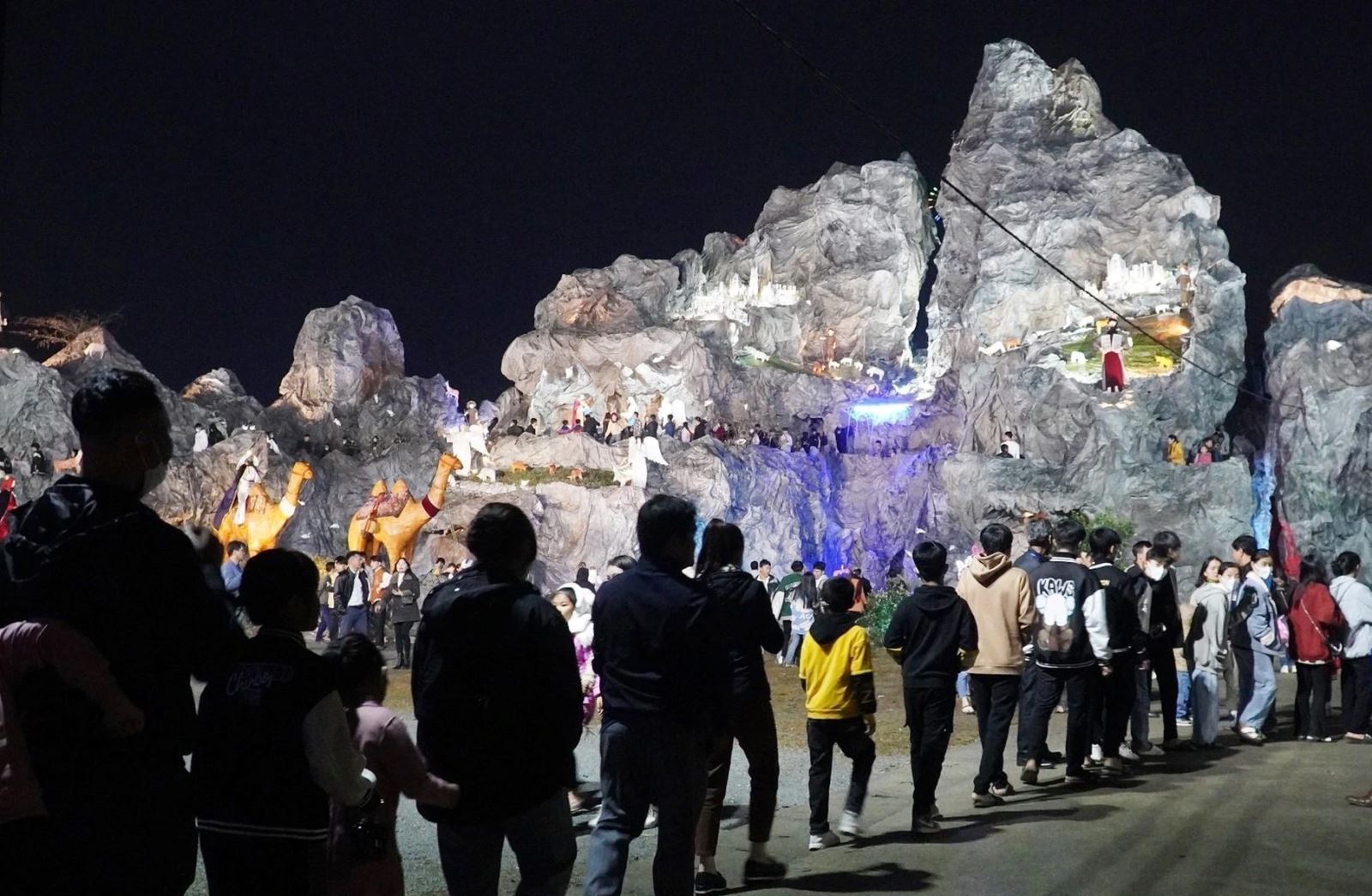 Tại TP Hà Tĩnh, hàng nghìn người đổ về nhà thờ Chính tòa Văn Hạnh để vui chơi, tham quan hang đá Bê-lem khổng lồ cao 25m, làm từ hàng nghìn cây tre. Hang đá có những hoạt cảnh sống động, đẹp mắt, ban an ninh - bảo vệ giáo xứ được phân công lực lượng để hướng dẫn người dân xếp hàng theo thứ tự để "rồng rắn" vào tham quan (Ảnh: Dương Nguyên).
