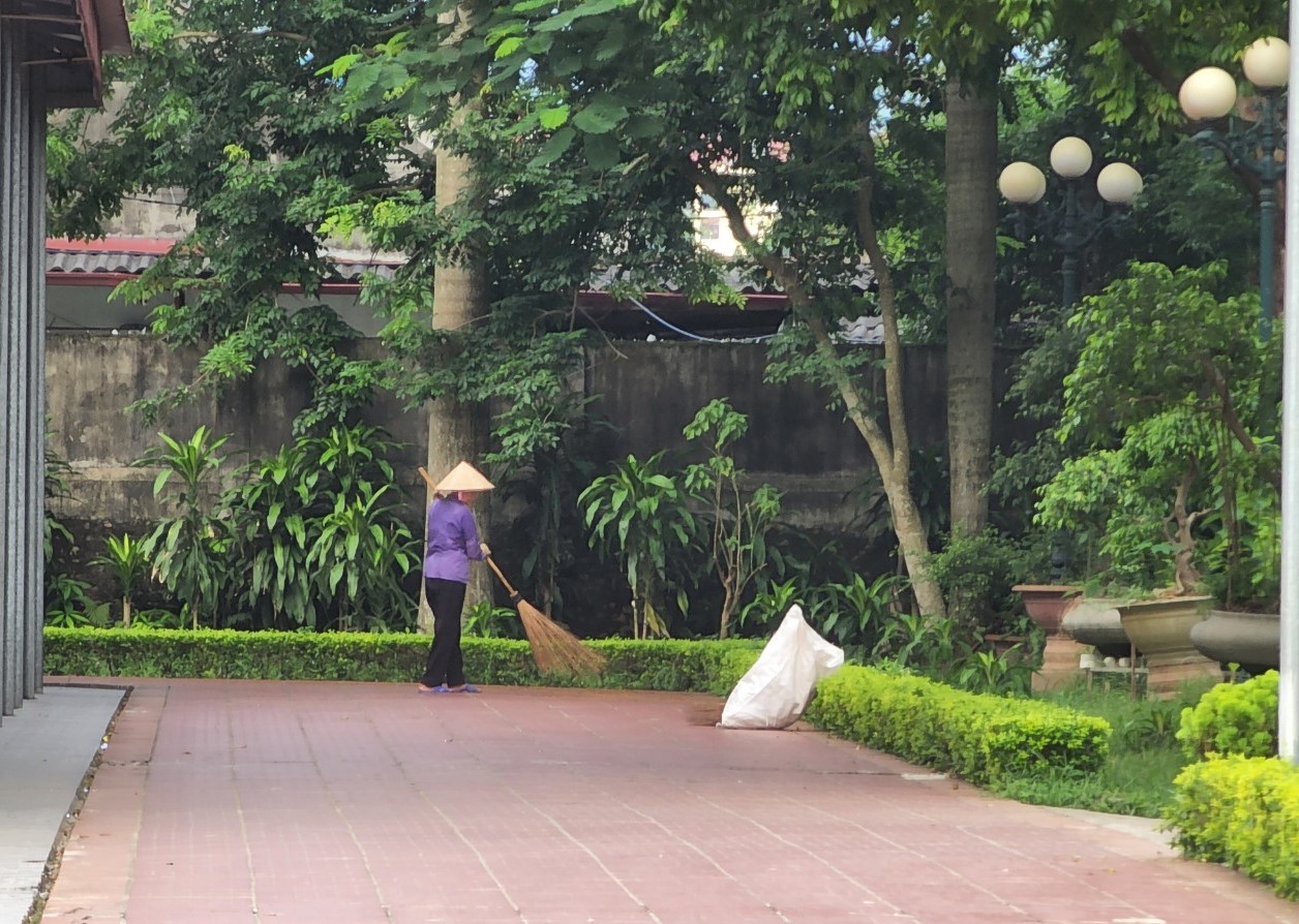 Giáo dân quét dọn lá rụng tại khu vực khuôn viên thánh đường.
