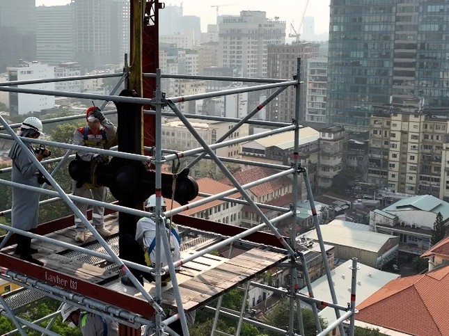 Công nhân đang chuẩn bị để cần cẩu nhấc Thánh giá lên và đưa xuống đất. 