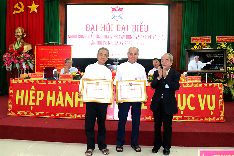 Linh mục Phêrô Trần Văn Kích (đứng giữa) nhận bằng khen của Trung ương UBĐKCG Việt Nam. 