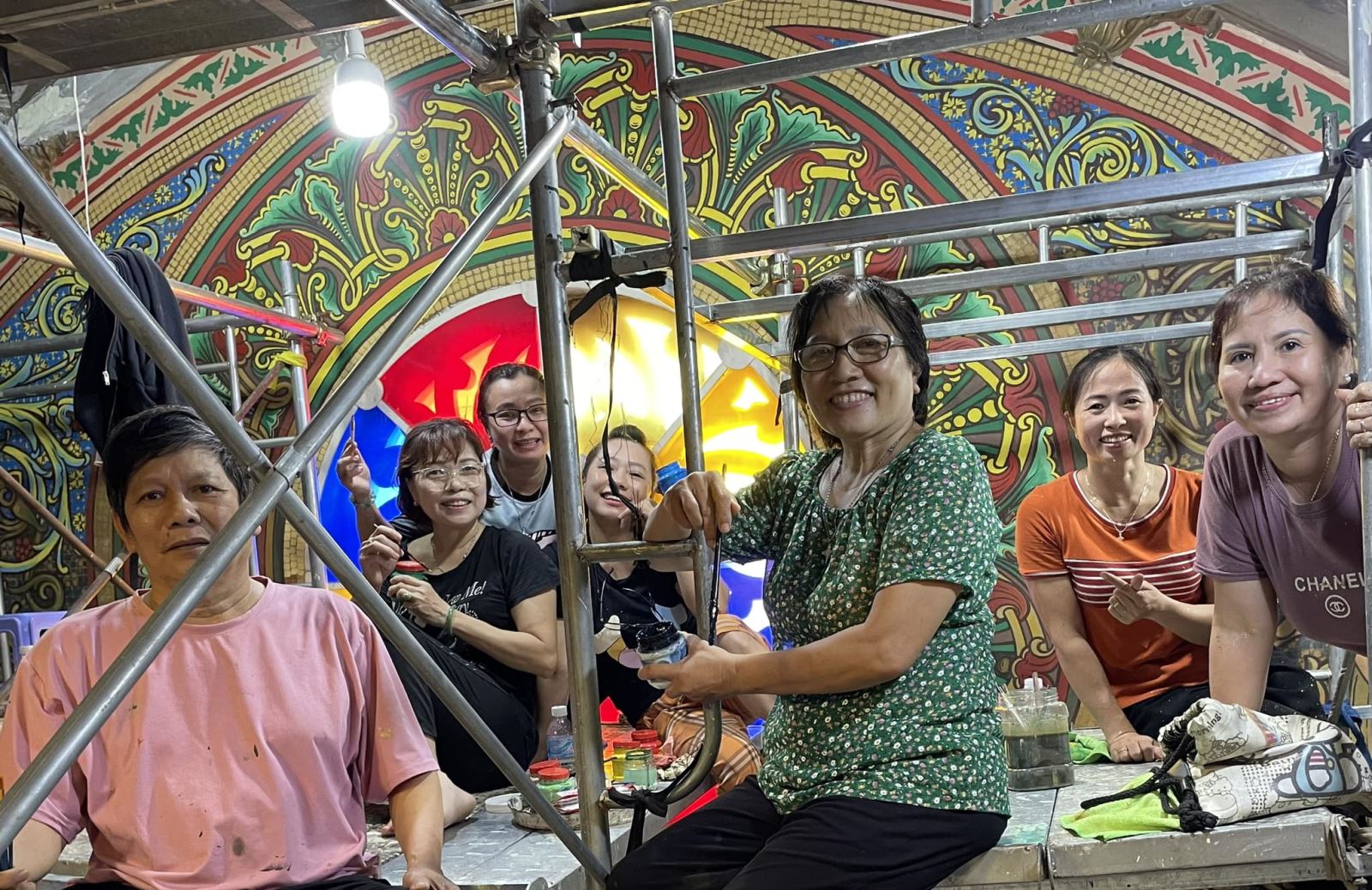 Họa sĩ Vũ Thái Sơn (ngoài cùng bên trái) cùng các “nghệ nhân không chuyên” đang vẽ lại các chi tiết trên trần nhà