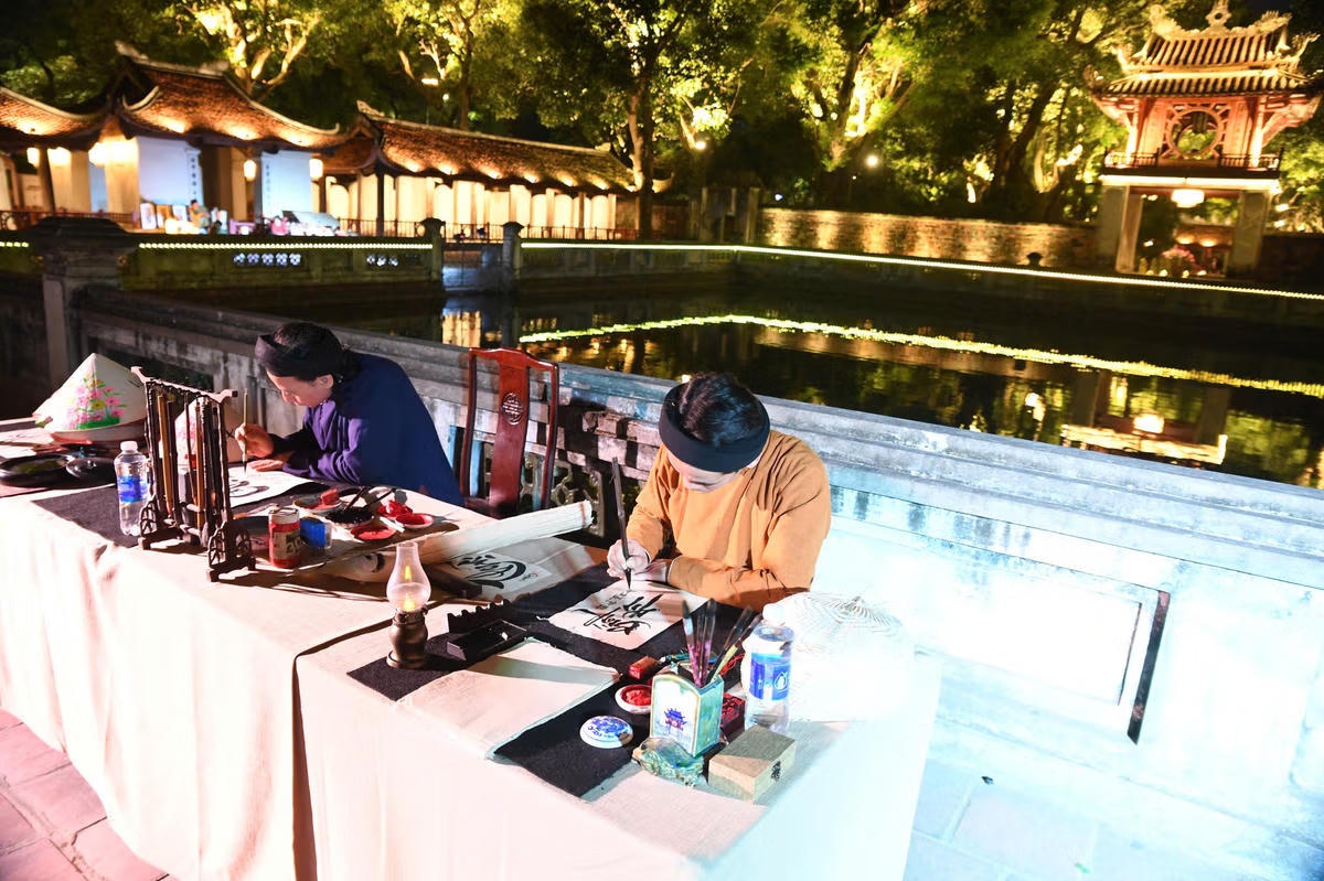 Viết thư pháp ở Văn Miếu - Quốc Tử Giám. Ảnh: P.Sỹ.