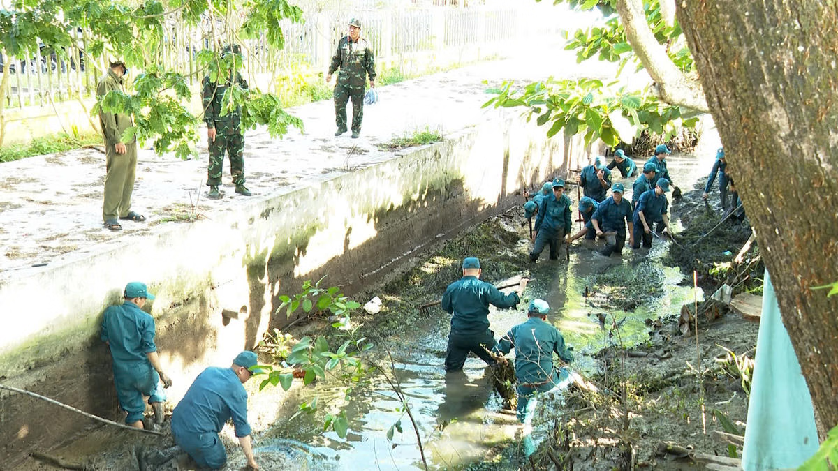 Từng gàu bùn được vét lên, dòng kênh dần thông thoáng hơn qua sự chung sức của cán bộ, chiến sĩ dân quân trong công trình dân vận vì cộng đồng. Ảnh Trung Ngãi